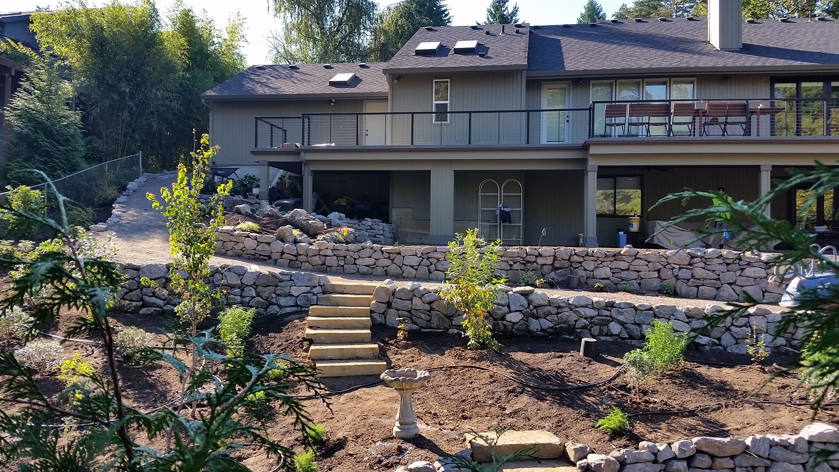 custom backyard landscaping- stone steps- rock walls- drip irrigation- gravel pathways- planting